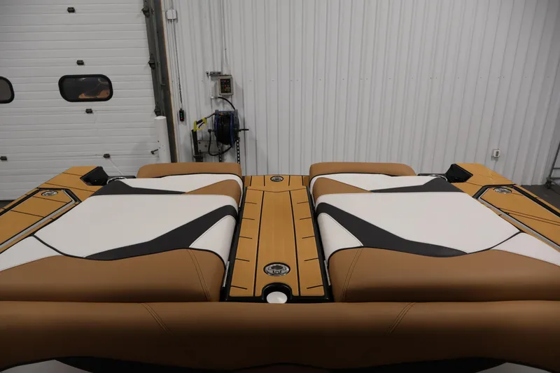 Slide: The Image of 2026 Centurion Fe22 boat interior with tan and white upholstery in a garage setting. - 38