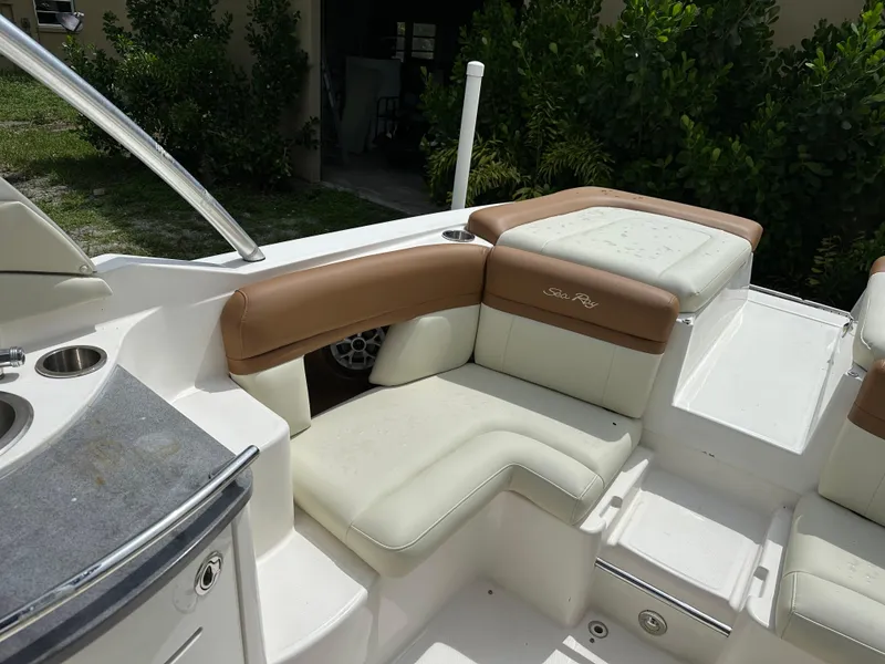 Slide: The Image of 2012 Sea Ray SLX 270 boat interior with white and tan seating, outdoor setting. - 10