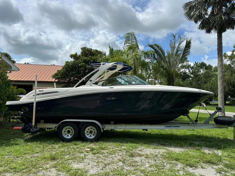 Slide: The Image of 2012 Sea Ray SLX 270 boat on trailer, parked outdoors with palm trees. - 20