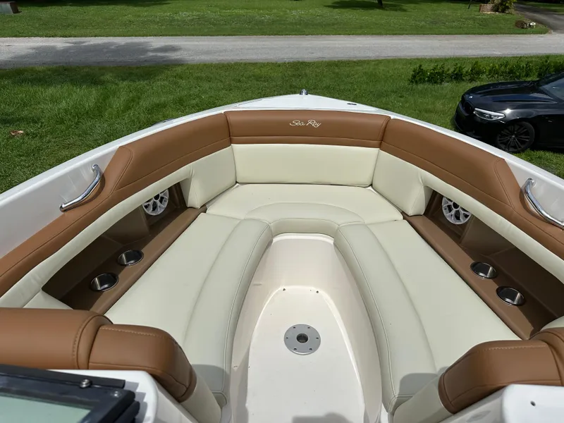 Slide: The Image of 2012 Sea Ray SLX 270 boat interior with tan and white seating, cup holders, and speakers. - 6