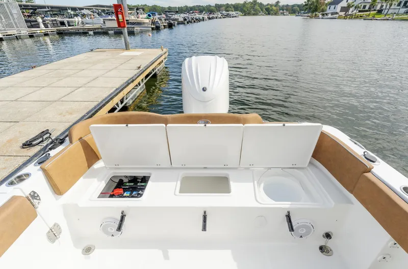Slide: The Image of 2025 Sea Hunt Ultra 235 SE boat at dock, featuring open storage compartments. - 10