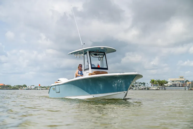 Slide: The Image of 2026 Sea Hunt Ultra 235 SE boat on calm water under cloudy sky. - 17