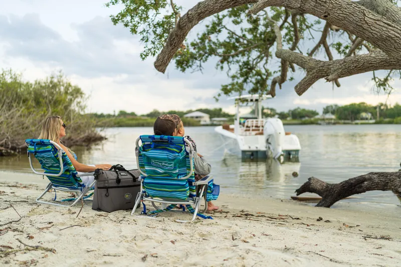Slide: The Image of People relaxing on a sandy beach with a 2026 Sea Hunt Ultra 235 SE boat nearby. - 22