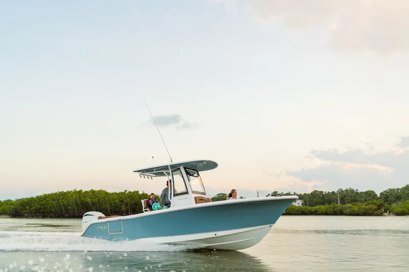 Slide: The Image of 2026 Sea Hunt Ultra 235 SE boat cruising on calm water at sunset. - 25