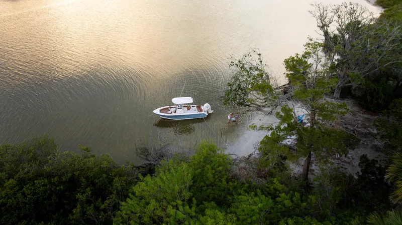 Slide: The Image of Aerial view of 2026 Sea Hunt Ultra 235 SE boat near a serene shoreline. - 26