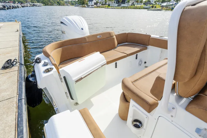 Slide: The Image of 2025 Sea Hunt Ultra 235 SE boat interior with tan seating by the water. - 5