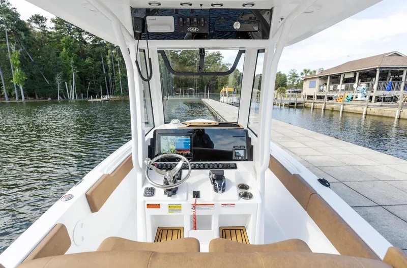 Slide: The Image of 2025 Sea Hunt Ultra 235 SE boat interior with steering console, dockside view. - 6