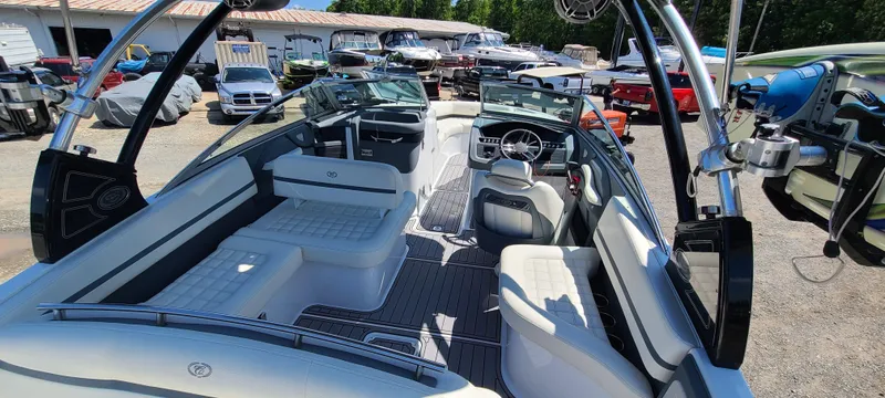 Slide: The Image of 2020 Cobalt R5 boat interior with white seating and sleek design, parked outdoors. - 26