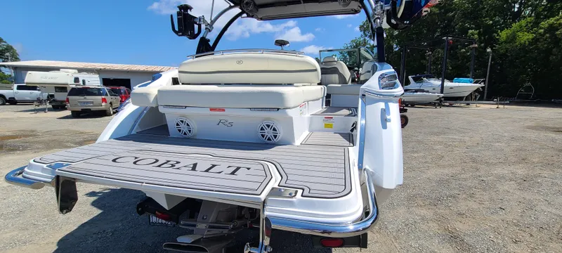 Slide: The Image of 2020 Cobalt R5 boat rear view with swim platform and seating, parked outdoors. - 4