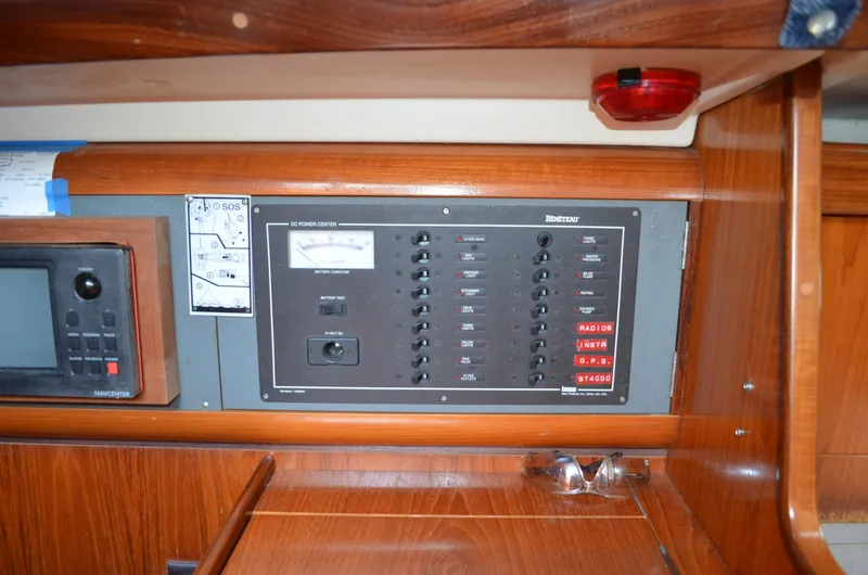 Slide: The Image of Electrical panel inside a 1993 Beneteau Oceanis 370 sailboat, featuring wooden cabinetry. - 10