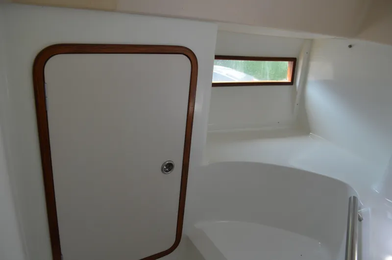 Slide: The Image of Interior of 1993 Beneteau Oceanis 370 sailboat, featuring a white cabin with wooden trim. - 13
