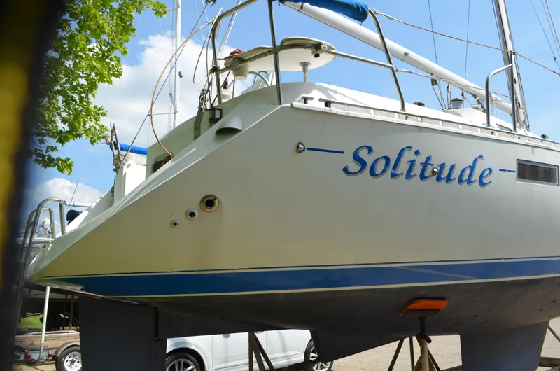 Slide: The Image of 1993 Beneteau Oceanis 370 sailboat named "Solitude" on dry dock, side view. - 2