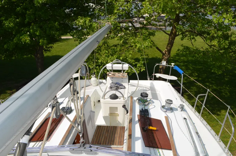 Slide: The Image of 1993 Beneteau Oceanis 370 sailboat deck with lush green surroundings. - 6