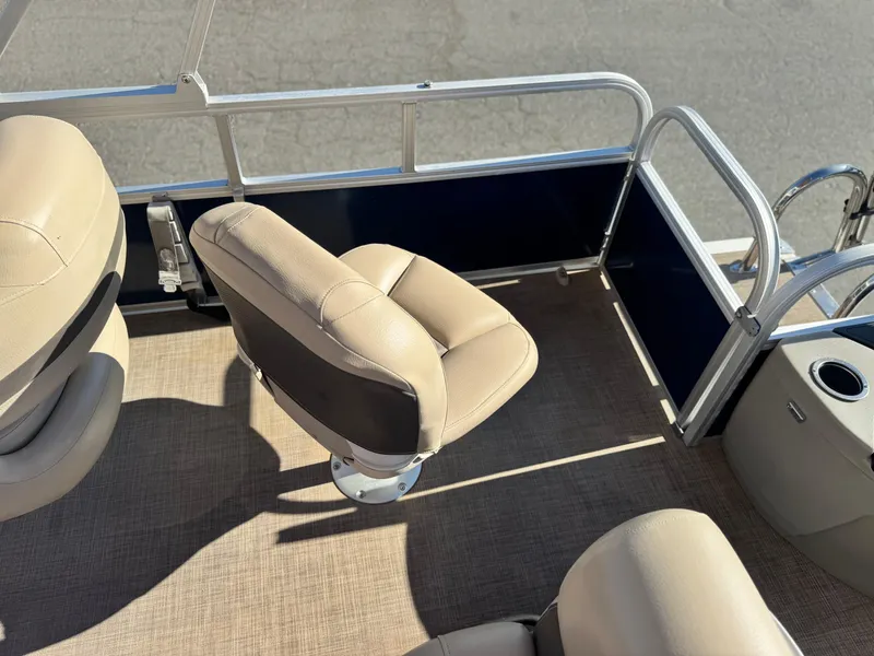 Slide: The Image of 2023 Sun Tracker Bass Buggy 18 DLX boat interior with beige seating and railing. - 17
