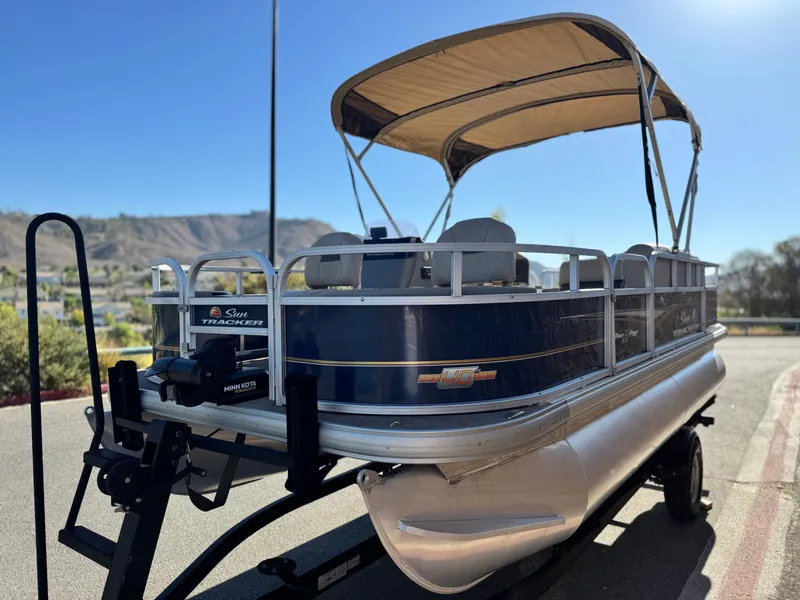 Slide: The Image of 2023 Sun Tracker Bass Buggy 18 DLX pontoon boat with canopy on trailer. - 3