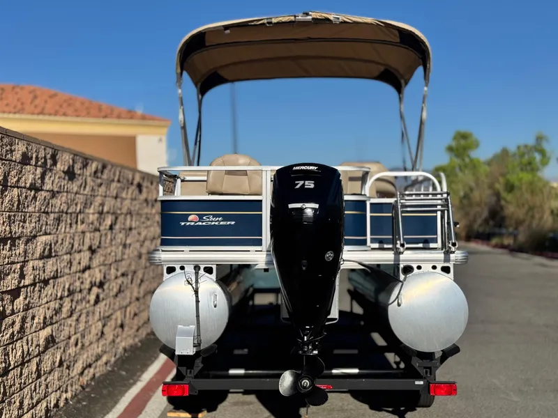 Slide: The Image of 2023 Sun Tracker Bass Buggy 18 DLX pontoon boat with Mercury 75 engine, parked outdoors. - 5