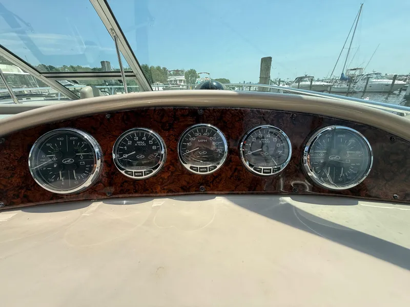 Slide: The Image of Dashboard of 2006 Sea Ray 290 Amberjack boat with gauges and wood paneling. - 12