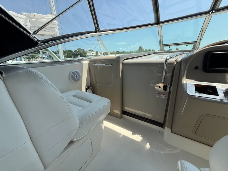 Slide: The Image of Interior view of 2006 Sea Ray 290 Amberjack boat with white seating and clear canopy. - 15