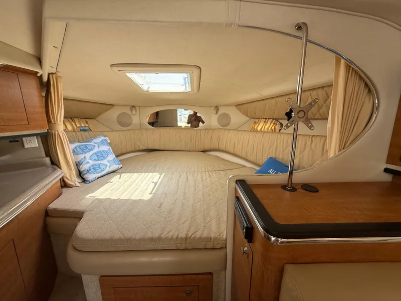 Slide: The Image of 2006 Sea Ray 290 Amberjack cabin interior with bed, skylight, and wooden cabinetry. - 17