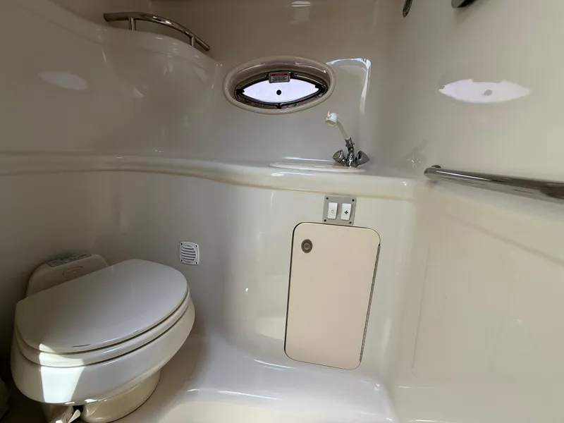 Slide: The Image of 2006 Sea Ray 290 Amberjack boat bathroom with toilet, sink, and porthole window. - 21