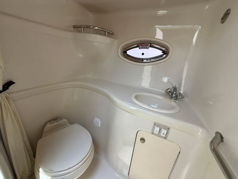 Slide: The Image of 2006 Sea Ray 290 Amberjack boat bathroom with toilet, sink, and porthole window. - 22