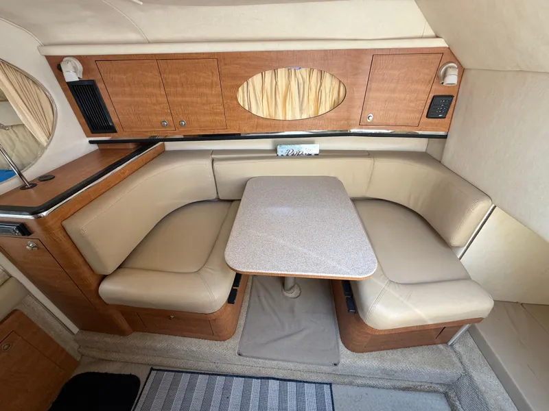 Slide: The Image of Interior of 2006 Sea Ray 290 Amberjack with beige seating and wooden cabinetry. - 26