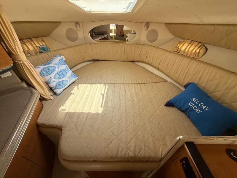 Slide: The Image of 2006 Sea Ray 290 Amberjack cabin interior with cozy bed and decorative pillows. - 29