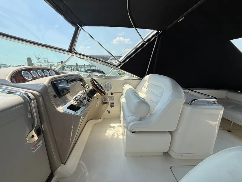 Slide: The Image of 2006 Sea Ray 290 Amberjack helm with white seating and dashboard controls. - 3