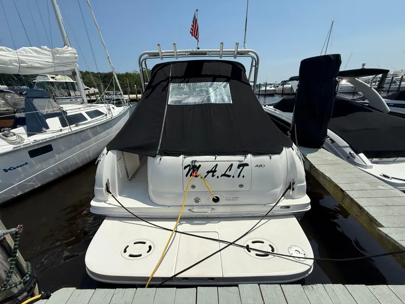 Slide: The Image of 2006 Sea Ray 290 Amberjack docked with black cover and American flag. - 30
