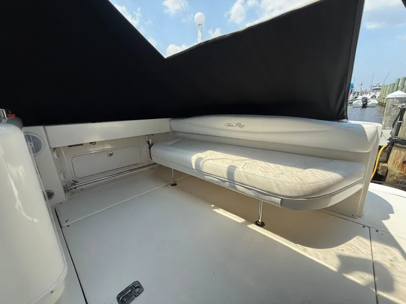 Slide: The Image of 2006 Sea Ray 290 Amberjack boat interior with cushioned seating and black canopy. - 5
