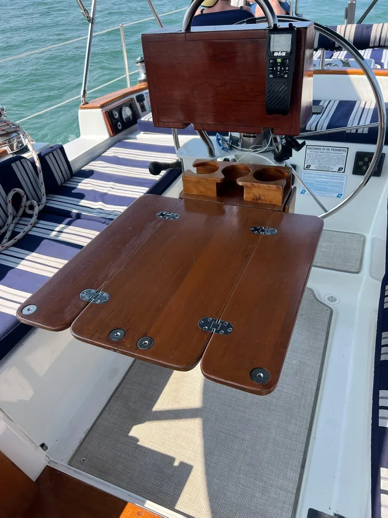 Slide: The Image of Cockpit of 1992 Endeavour 45 sailboat with wooden table and striped seating. - 13