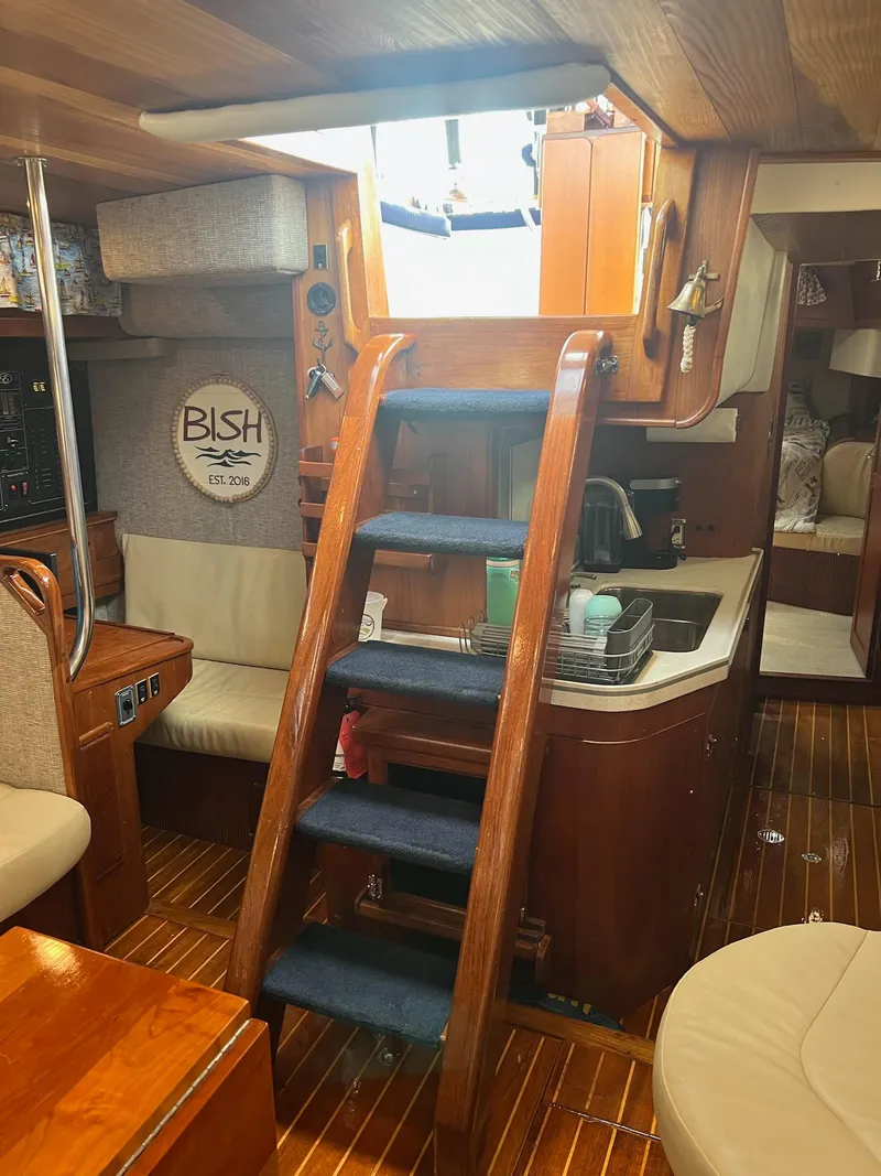 Slide: The Image of Interior of 1992 Endeavour 45 sailboat with wooden stairs and compact kitchen area. - 18