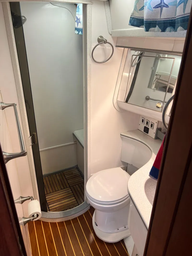 Slide: The Image of Compact bathroom in a 1992 Endeavour 45 yacht with shower, toilet, and wooden flooring. - 24