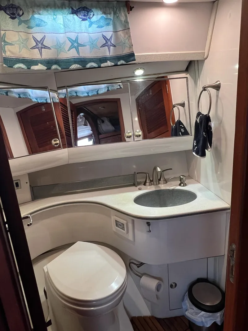 Slide: The Image of Compact bathroom in a 1992 Endeavour 45 yacht, featuring a sink, toilet, and nautical decor. - 28