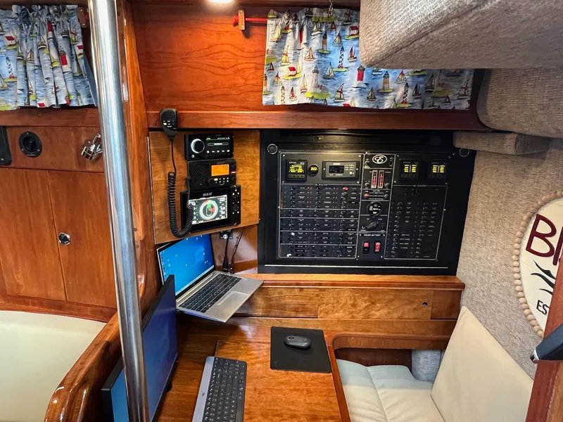 Slide: The Image of Navigation station inside a 1992 Endeavour 45 sailboat with control panels and laptops. - 29