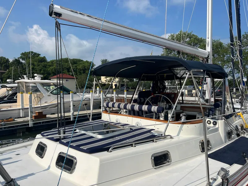 Slide: The Image of Sailboat Endeavour 45, 1992 model, docked at marina with blue canopy and striped seating. - 5