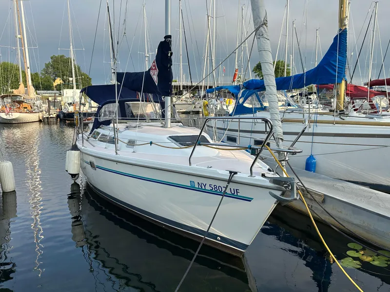 Slide: The Image of 1997 Catalina 28 MkII sailboat docked in a marina, surrounded by other boats. - 1