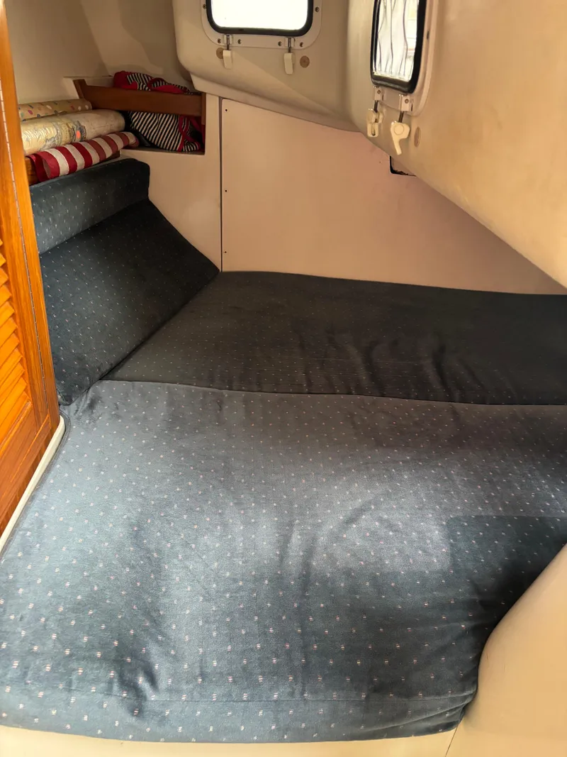 Slide: The Image of Cozy cabin interior of a 1997 Catalina 28 MkII sailboat with blue bedding. - 11