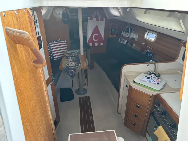 Slide: The Image of Interior of a 1997 Catalina 28 MkII sailboat, featuring a cozy cabin and kitchenette. - 13