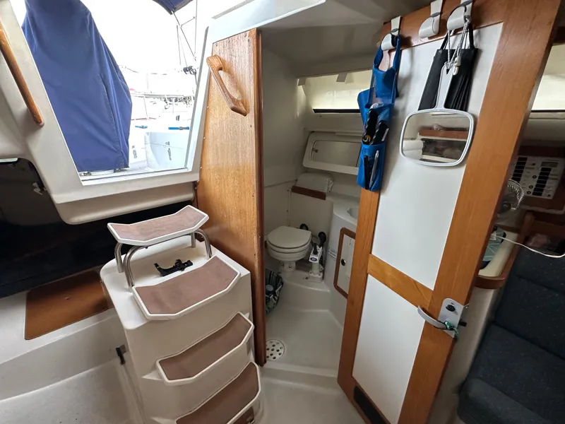 Slide: The Image of Interior of 1997 Catalina 28 MkII sailboat showing compact bathroom and wooden cabinetry. - 14