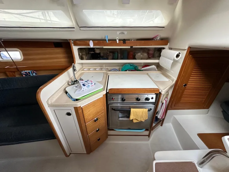 Slide: The Image of 1997 Catalina 28 MkII yacht kitchen with stove, sink, and storage cabinets. - 15