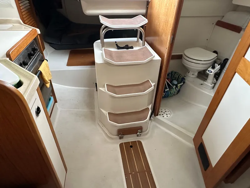 Slide: The Image of Interior of a 1997 Catalina 28 MkII sailboat, featuring a compact kitchen and bathroom. - 18