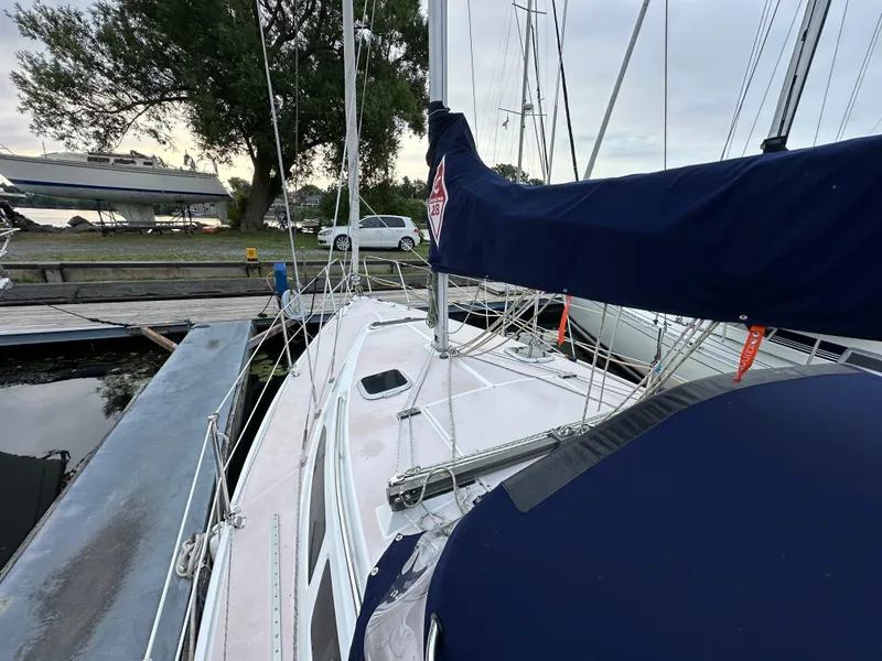 Slide: The Image of 1997 Catalina 28 MkII sailboat docked, featuring a blue sail cover and marina surroundings. - 21