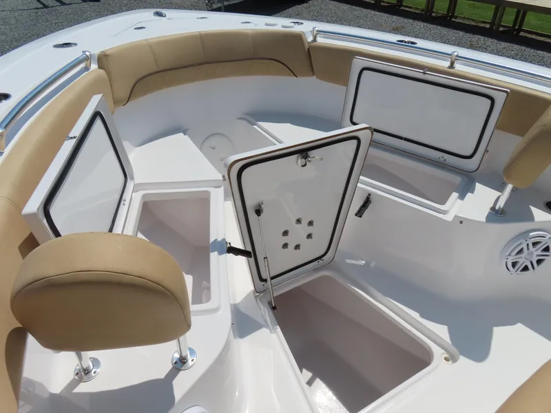 Slide: The Image of 2018 Sportsman Heritage 251 Center Console boat with open storage compartments and cushioned seating. - 13