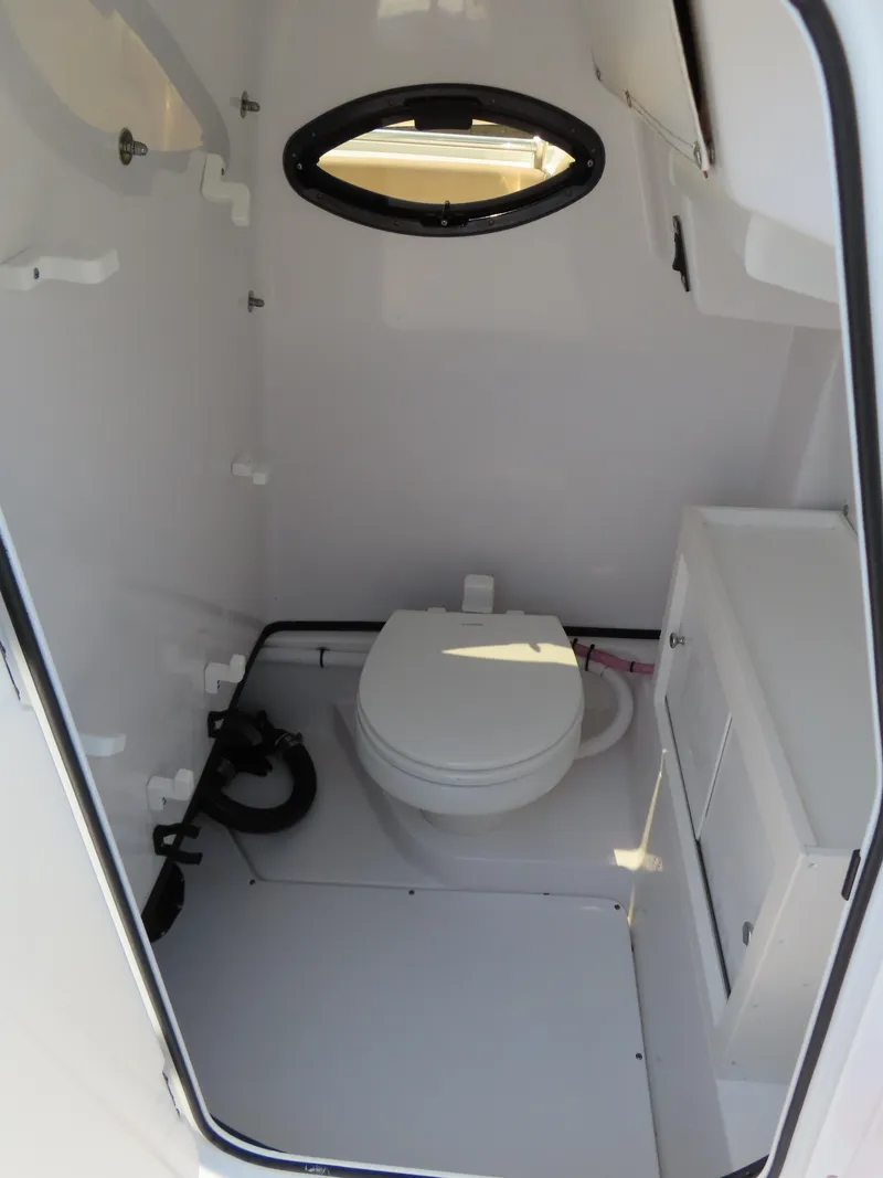Slide: The Image of 2018 Sportsman Heritage 251 Center Console boat interior with compact marine toilet. - 25