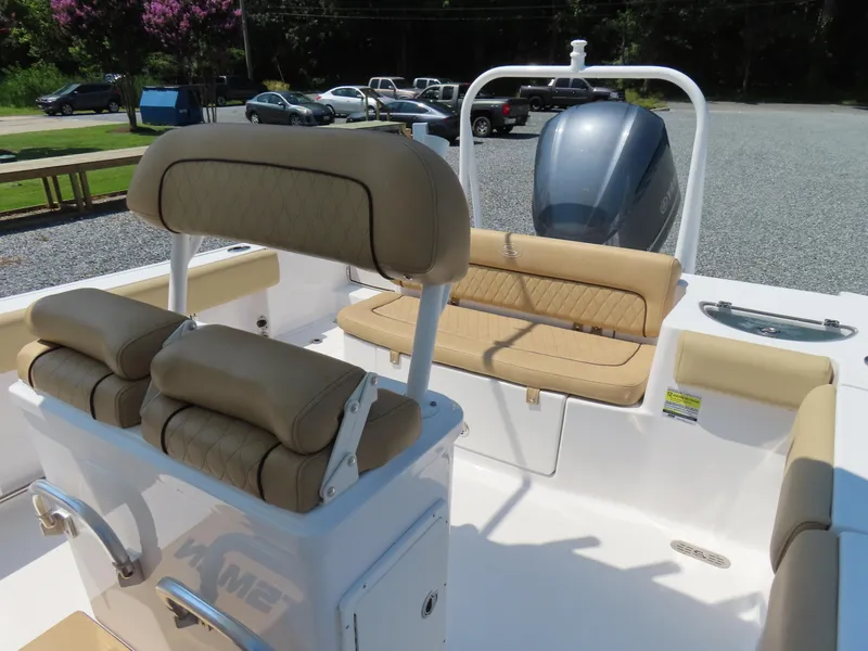 Slide: The Image of 2018 Sportsman Heritage 251 Center Console boat interior with tan seating and outboard motor. - 26