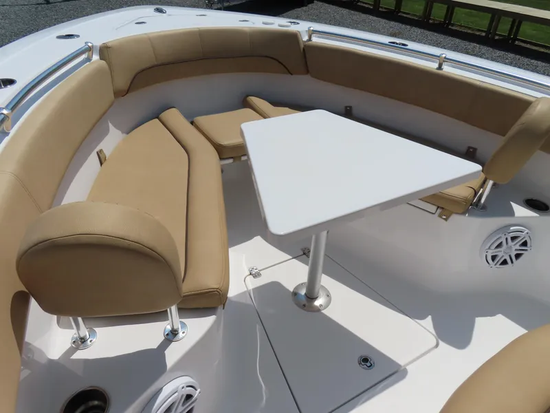 Slide: The Image of 2018 Sportsman Heritage 251 Center Console boat interior with tan seating and white table. - 7