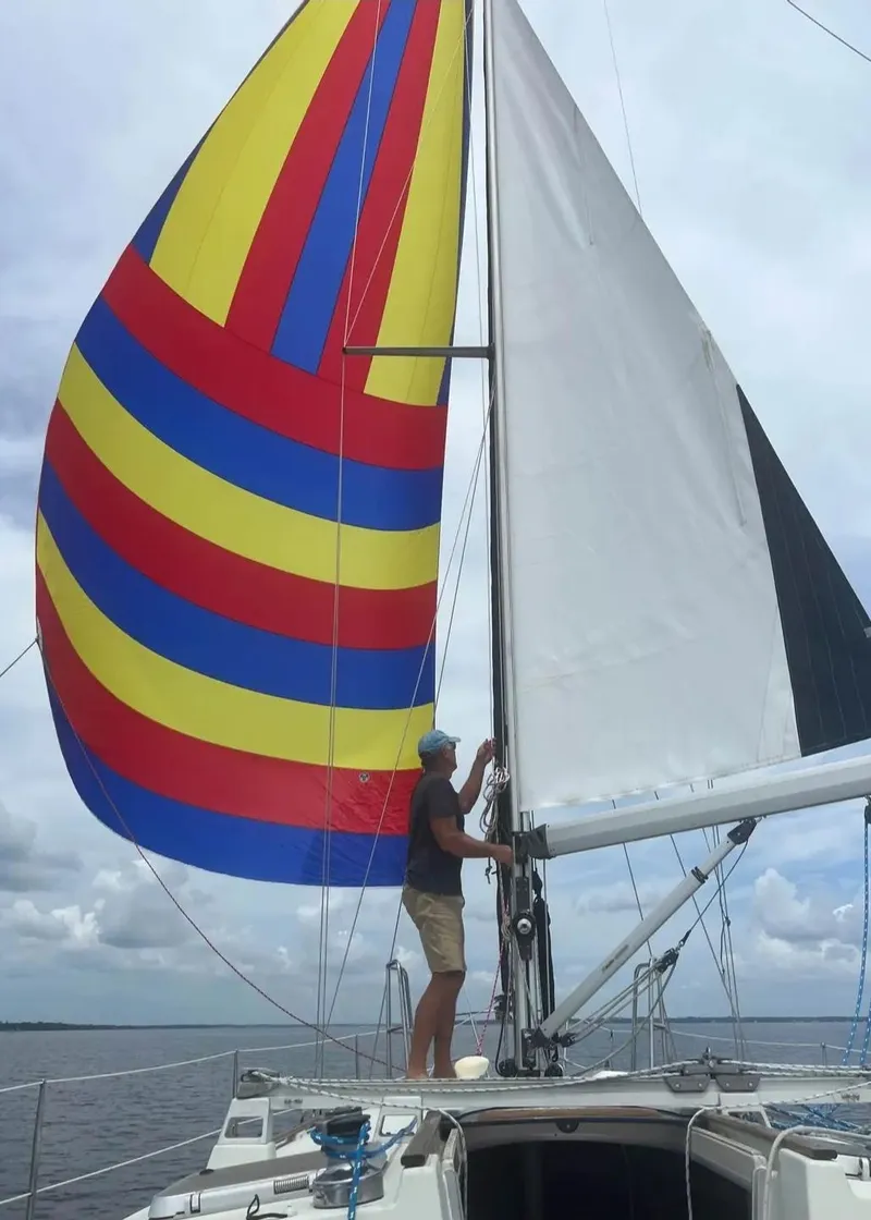 Slide: The Image of Sailboat Beneteau MOORINGS 38, 1991, with colorful spinnaker sail on open water. - 13