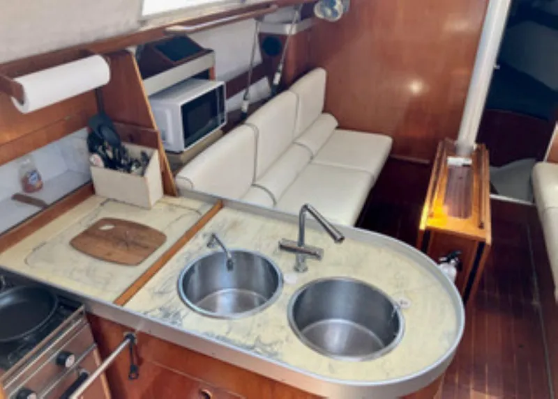 Slide: The Image of Interior of 1991 Beneteau MOORINGS 38 yacht with kitchen and seating area. - 6