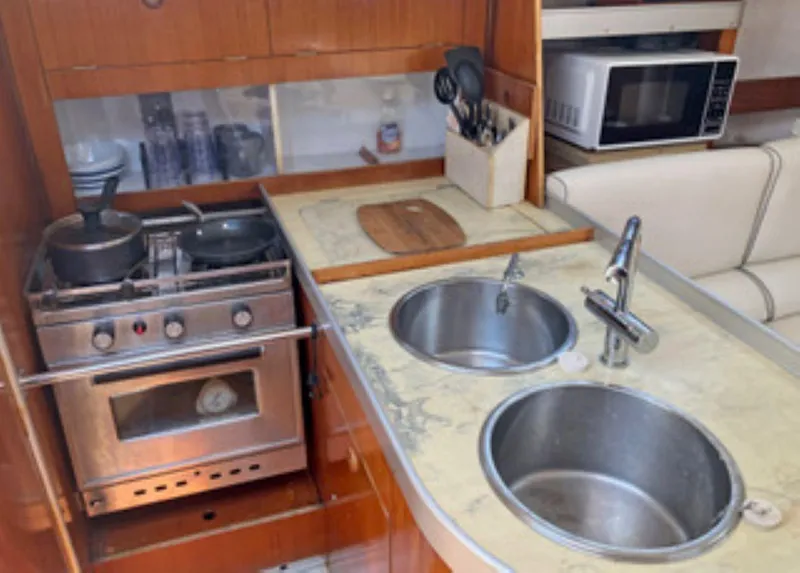 Slide: The Image of Galley kitchen in 1991 Beneteau MOORINGS 38 yacht with stove, sink, and microwave. - 7